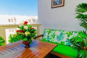 una mesa de madera con un jarrón de flores. en Porto Said Resort Rentals en Port Said