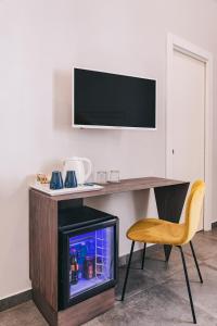 a desk with a television and a chair next to it at La Smorfia in Naples