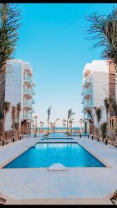 una gran piscina con palmeras y edificios en Porto Said Resort Rentals en Port Said
