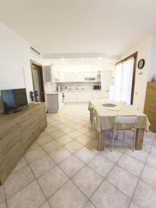 ein Wohnzimmer mit einem Tisch und einer Küche in der Unterkunft Casa vacanze Le Gardenie in Conegliano