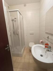 een badkamer met een douche, een wastafel en een toilet bij Casa vacanze Le Gardenie in Conegliano
