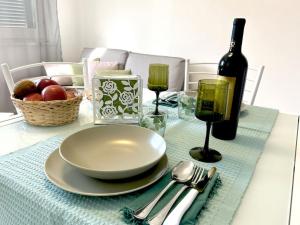 une table avec une assiette et une bouteille de vin dans l'établissement appartamento la torre, à Pietrasanta 26 autres photos