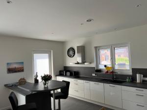 a kitchen with white cabinets and a table in it at Ferienhaus RELAX in Büsum