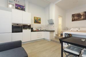 kuchnia i salon z białymi szafkami i stołem w obiekcie 1 bedroom 1 bathroom furnished - Av de America - studio - MintyStay w Madrycie