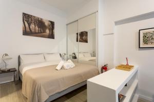 ein weißes Schlafzimmer mit einem Bett und einem Spiegel in der Unterkunft 1 bedroom 1 bathroom furnished - Av de America - studio - MintyStay in Madrid