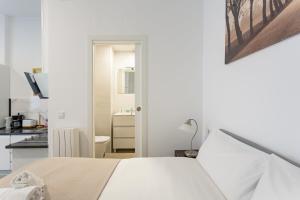 biała sypialnia z łóżkiem i kuchnią w obiekcie 1 bedroom 1 bathroom furnished - Av de America - studio - MintyStay w Madrycie +6 zdjęć