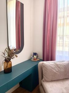 Cette chambre comprend un miroir, un lit et une fenêtre. dans l'établissement Lux City Apartments & Rooms, à Sarajevo