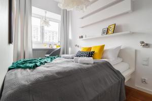 a bedroom with a bed with yellow and white pillows at Chłodna 15 by Homeprime in Warsaw