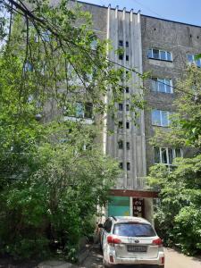 un coche aparcado frente a un edificio en HappyTerra, район ТРЦ "АДК" en Almaty