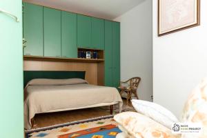 een slaapkamer met een bed en een groene kast bij Casa Liviya - Appartamento con vista lago in Madonna del Sasso