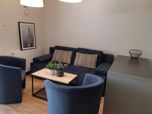 sala de estar con sofá azul y mesa en domki apartamenty Nasza Chata - 4 minuty od plaży, en Pobierowo