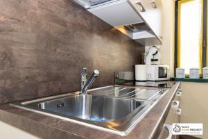 Casa Valentino - Appartamento con vista في Madonna del Sasso: يوجد حوض مطبخ حديد قابل للصدأ في المطبخ