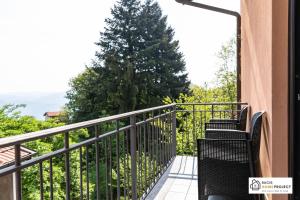 - un balcon avec deux chaises et un arbre dans l'établissement Casa Valentino - Appartamento con vista, à Madonna del Sasso