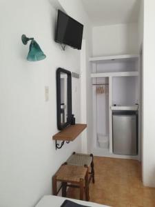 Zimmer mit einem Spiegel, einem Tisch und einem Spiegel in der Unterkunft Zinas pension in Chora, Ios