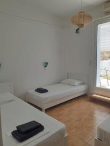 Habitación blanca con cama y ventana en Zinas pension en Ios Chora