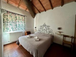 a bedroom with a bed with two towels on it at L'Aiolina in Vagliagli