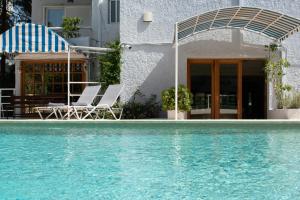 una casa con 2 sillas y una piscina en Stefanakis Hotel & Apartments, en Varkiza