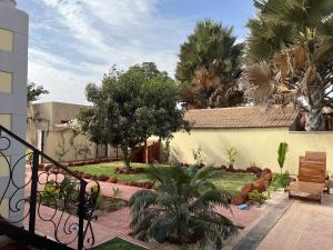 un patio con palmeras y un edificio en Chez Lilie Maison d'hôtes à Saly, en Saly Portudal