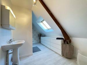 a bathroom with a sink and a skylight at Les écuries à 12 mn de Cabourg in Goustranville