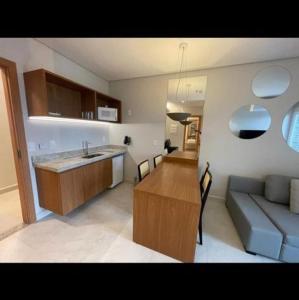 Salinas Exclusive Resort في سالينوبوليس: مطبخ وغرفة معيشة مع أريكة وطاولة