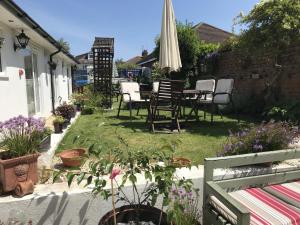 a patio with a table and chairs and an umbrella at Lilac Villa Guest House in Weymouth