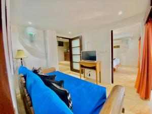 a blue couch in a living room with a television at Lembongan Harmony Villas in Nusa Lembongan