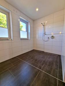 baño con ducha y suelo de baldosa. en Exklusive Ferienwohnung in Lingen Holthausen 2Zim, 2Badez,Küche,Balkon,Waschmaschine, en Lingen