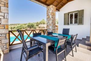 a dining room with a table and chairs on a balcony at Villa Luna in Kavála