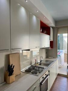 una cucina con mobili bianchi e un forno a piano cottura di Großzügige Wohnung in zentraler Lage mit Balkon a Sarandë