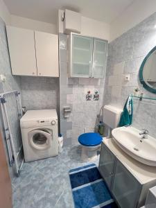 a bathroom with a washing machine and a sink at Lovely home - Free parking in Budapest
