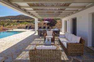 un patio con muebles de mimbre y una piscina en The Gallery Home, en Antíparos