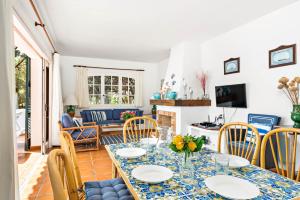 a dining room and living room with a table and chairs at Vista Mar in Cala Galdana