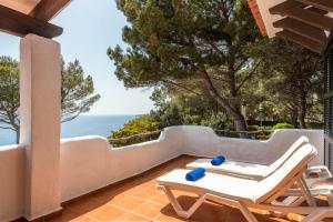 a patio with a table and chairs and the ocean at Vista Mar in Cala Galdana