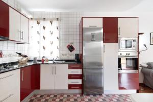 La cuisine est équipée de placards rouges et blancs et d'un réfrigérateur. dans l'établissement Casita Las Lagunetas, à Las Lagunetas