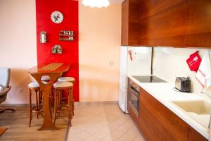 a kitchen with a small table and a red wall at Lovely home - Free parking in Budapest