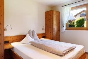 um quarto com uma cama branca e uma janela em Cornelia Latsche em Castelrotto