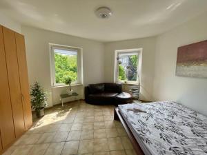 um quarto com uma cama, um sofá e 2 janelas em Nostalgie Apartment - 3 Zimmer, 5 Betten, 7 Personen, kontaktloses Einchecken, Netflix em Wuppertal