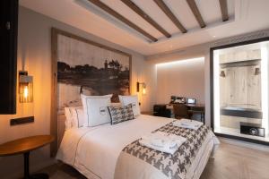 a bedroom with a large white bed and a window at Hotel Santo Crist La Ciudadela Marbella in Marbella