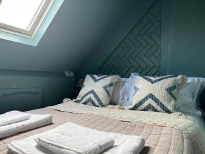 a bed with two white towels on top of it at Quirky Luxury Barn Sleeps 8, Pet Friendly in Calne