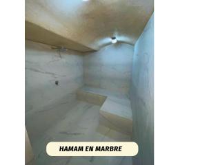 un baño con suelo de mármol blanco y una señal que lee hamann en mariere en Villa de Luxe - Agadir City, en Agadir