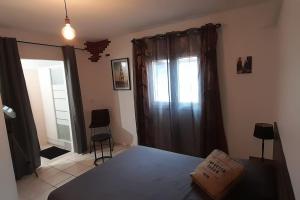 um quarto com uma cama e uma janela com cortinas em Maison cosy avec piscine em La Possession