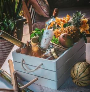 a chest filled with a bottle of perfume and fruit at Bungalow La Coulée d'Or in Le Vauclin