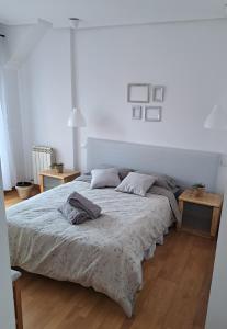 een witte slaapkamer met een bed met een deken bij La Casa del Ciprés in Aldeamayor de San Martín