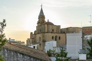 un vecchio edificio con una torre dell'orologio in una città di Casa Palacio Rufina & Jardines a Jerez de la Frontera