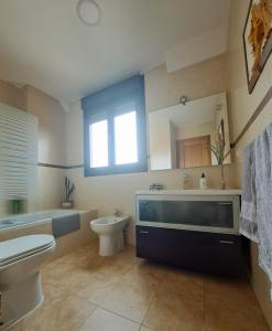 un bagno con un water, una vasca e un lavandino di La Casa del Ciprés a Aldeamayor de San Martín