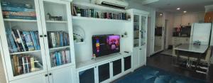 una camera con libreria e TV di Queen Property a Shah Alam