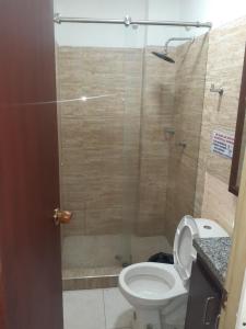 uma casa de banho com um WC e uma cabina de duche em vidro. em EstanciaS ALELI comodo apart/std, Aero/pto,t/Nal de transporte em Cali