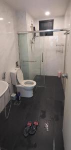 een badkamer met een toilet en een glazen douche bij Queen Property in Shah Alam