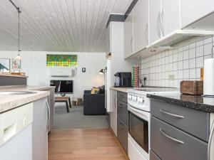 a kitchen with white appliances and a living room at 6 person holiday home in Bjert-By Traum in Bjert Strand