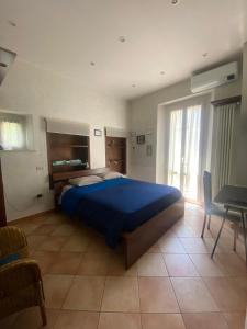 una camera con un grande letto blu e un tavolo di Pigiotto a Pesaro